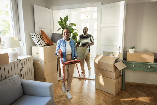 Young couple moving in to their new home, unpacking boxes and enjoying the time together.