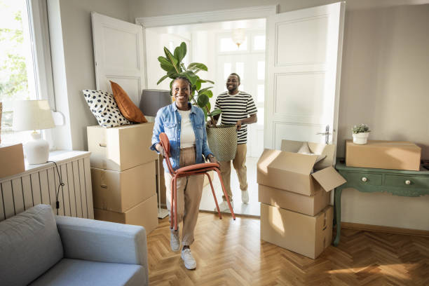 Young Couple with boxes Moving in New Home Young couple moving in to their new home, unpacking boxes and enjoying the time together. home ownership stock pictures, royalty-free photos & images