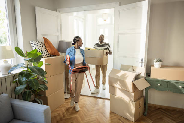 istock Young Couple with boxes Moving  in New Home 1565821625