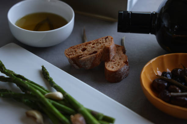 Fresh green asparagus on white plate with olive oil