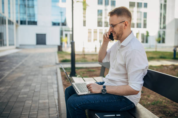 istock A young handsome businessman using his mobile phone while he is working outside 1565838372