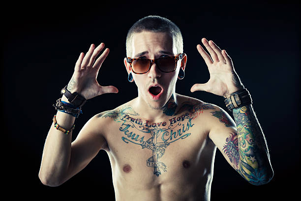 jovem homem com tatuagens - expressing negativity sullen 20s attractive male imagens e fotografias de stock
