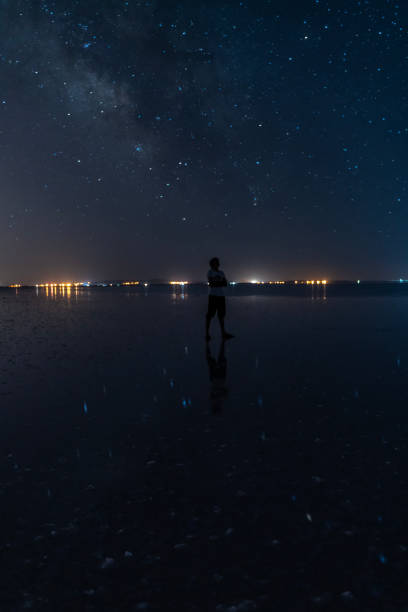 istock Young man looking at Milky Way view in Salt Lake. 1565852437
