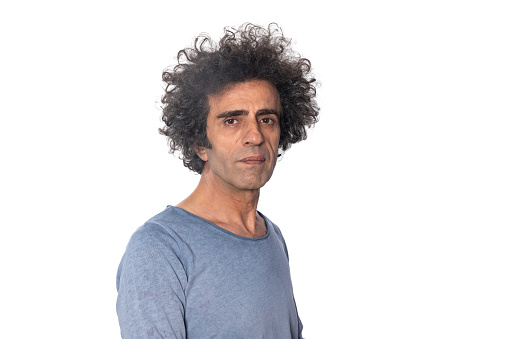 Portrait of mature adult man with long curly hair on white background. Shot in studio with a full frame mirrorless camera.