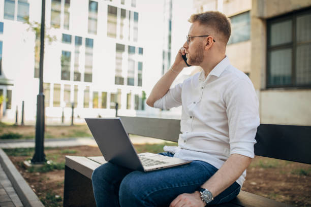 istock A young handsome businessman using his mobile phone while he is working outside 1565870311