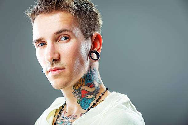 portrait d'un jeune homme avec des tatouages - pierced photos et images de collection