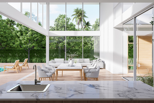 Modern style white house interior with wooden terrace 3d render,decorated with white furniture,There are large open sliding door Overlooking swimming pool and nature view.