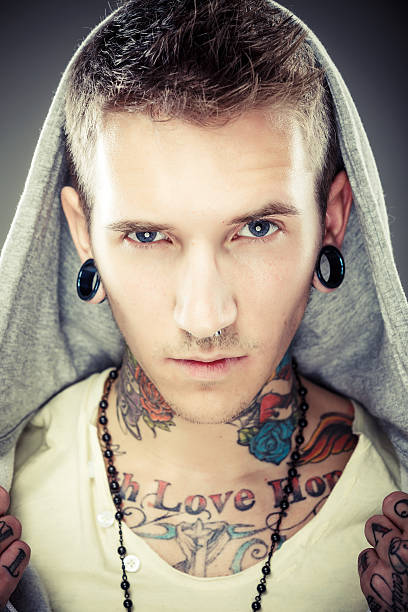 retrato de um jovem homem com muitas tatuagens - expressing negativity sullen 20s attractive male imagens e fotografias de stock