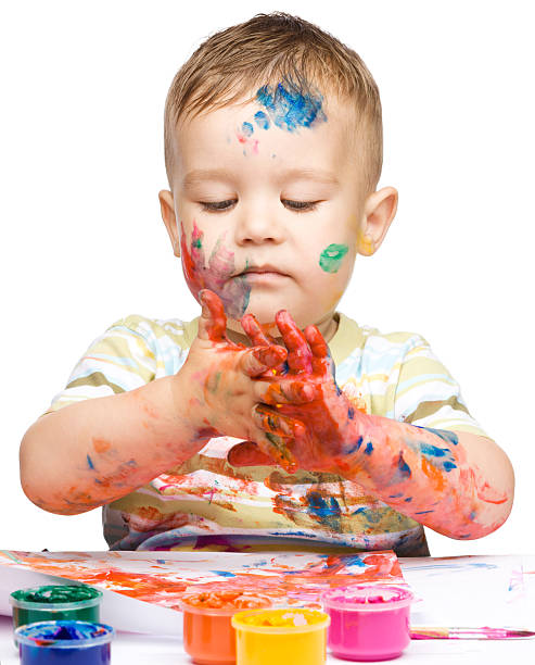 Little boy is playing with paints stock photo