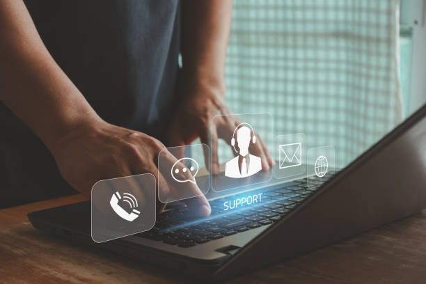 istock Technical Support Center Customer Service Internet Business Technology Concept. Person hand using smartphone with VR screen support customer icon, it support, call center and customer service help. 1565917164