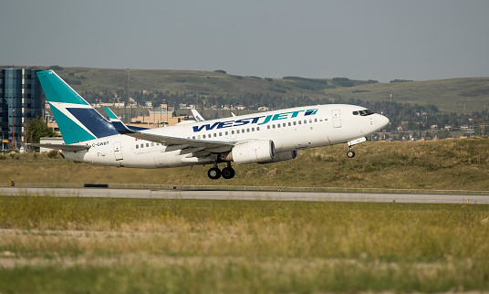 July 22, 2023. Calgary, Alberta, Canada. A WestJet Airlines Boeing 737-700, with identification C-GWBT, taking off from Calgary International Airport