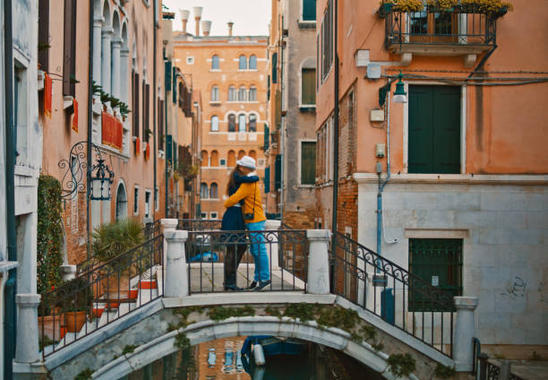 istock Mid adult couple embracing on bridge during vacation 1565930400