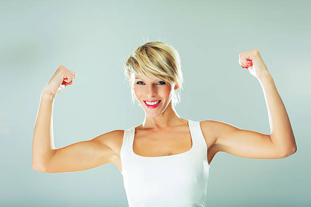 istock Young beautiful woman showing her muscles 156596009