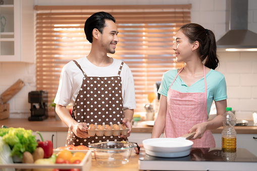 Asian couple feel happy and enjoy cooking together in home kitchen.
