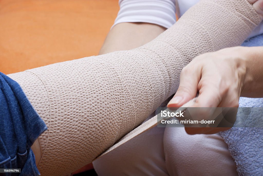 Personal de enfermería bandaged el pie de un paciente - Foto de stock de Venda libre de derechos