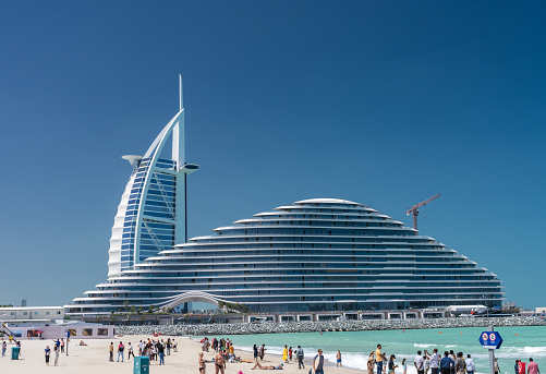 Dubai, UAE - 2 April 2023: Burj al Arab behind Marsa al Arab hotels in Jumeirah from public beach