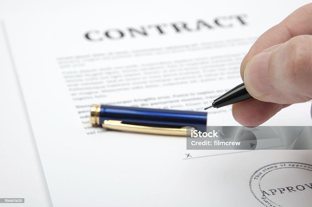 Contract signing Hand holding a pen, ready to close the deal and sign the contract. Agreement Stock Photo