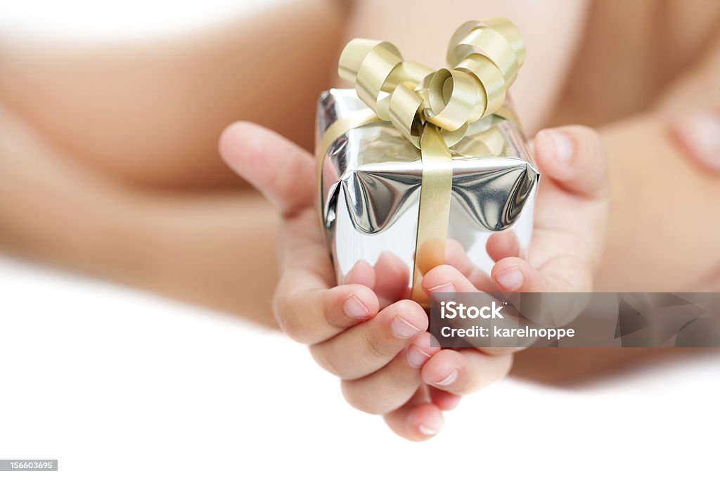 Close up of babies hands holding present. Macro close up of babies hands holding small present. Isolated. Anniversary Stock Photo