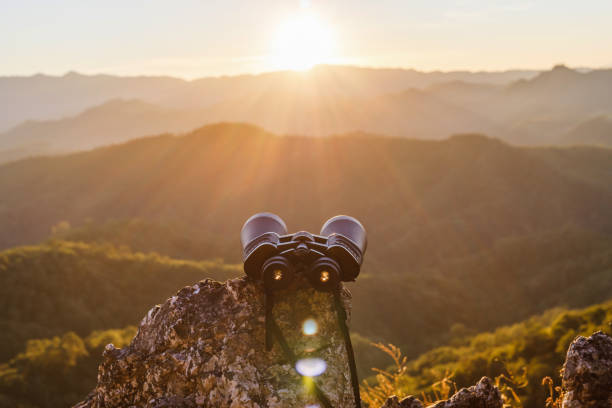 istock binoculars on top of rock mountain at beautiful sunset background. 1566049895