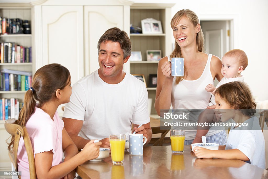 Family Having Breakfast In Kitchen Together Family Having Breakfast In Kitchen Together Talking And Laughing Family Stock Photo