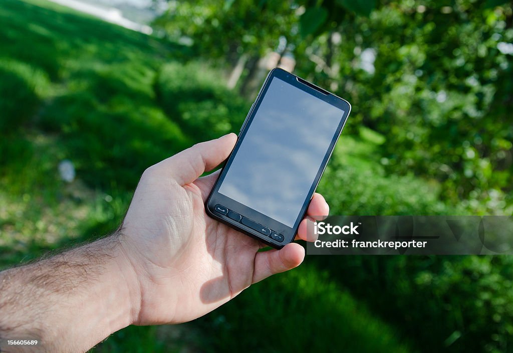 Branco segurando um telefone móvel ao ar livre - Foto de stock de Branco royalty-free