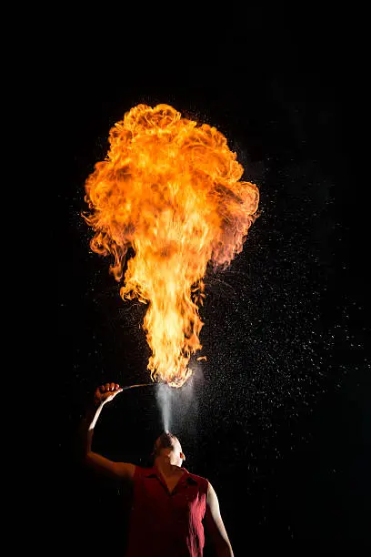 Fire breather blowing a fire ball from his mouth