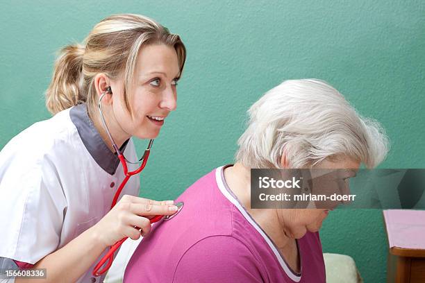 Photo libre de droit de Médecin Examiner Senior Avec Stéthoscope banque d'images et plus d'images libres de droit de Adulte - Adulte, Aide familiale, Auscultation au stéthoscope