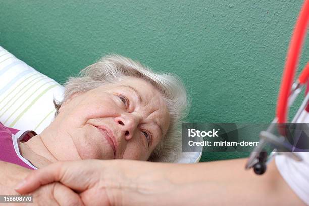 Foto de Médico Recebe Paciente Deitado Na Cama e mais fotos de stock de 70 anos - 70 anos, Adulto, Avó