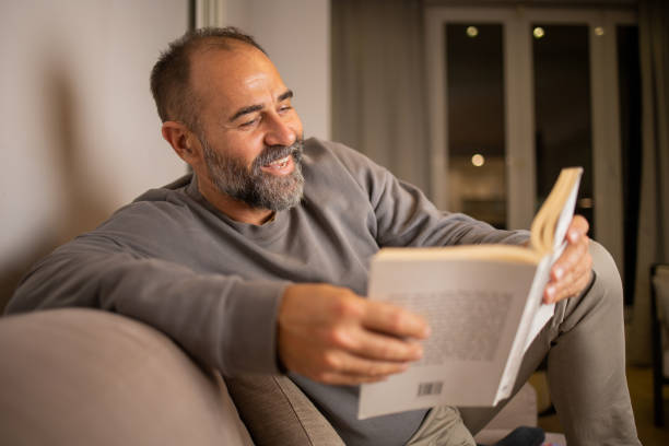 istock Mid adult man is reading a book 1566096709