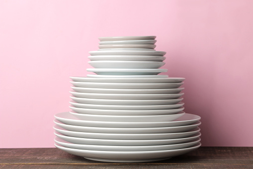 Heap of white color porcelain plates and bowls on the marble background