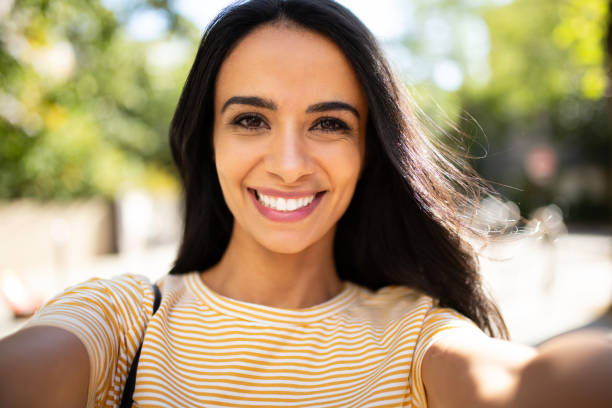 istock Smiling hispanic young woman taking selfie outside 1566126292