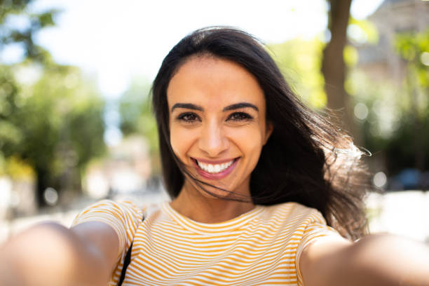 istock Beautiful young woman taking selfie outside 1566127359