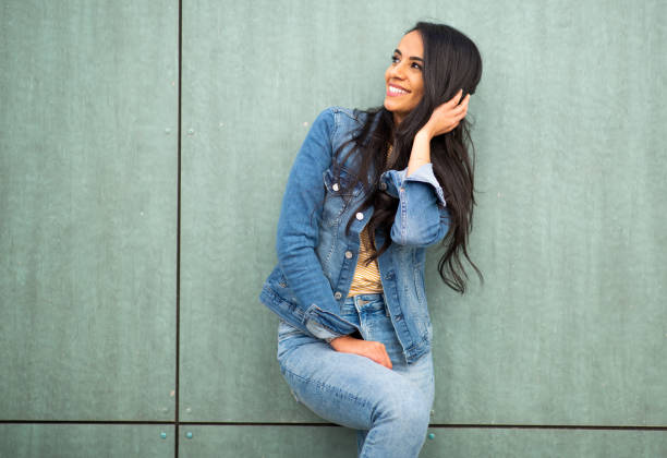 istock Pretty young hispanic woman posing against green wall 1566128419