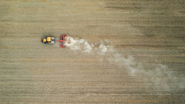 istock Crawler tractor harrowing and leveling soil for next seeding in rural plain fields 1566133351