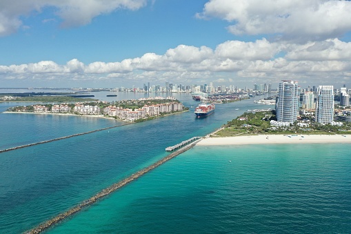 Miami Beach, Florida - May 23, 2020 - Aerial view of container ship in Government Cut leaving Port Miami on sunny calm summer morning.
