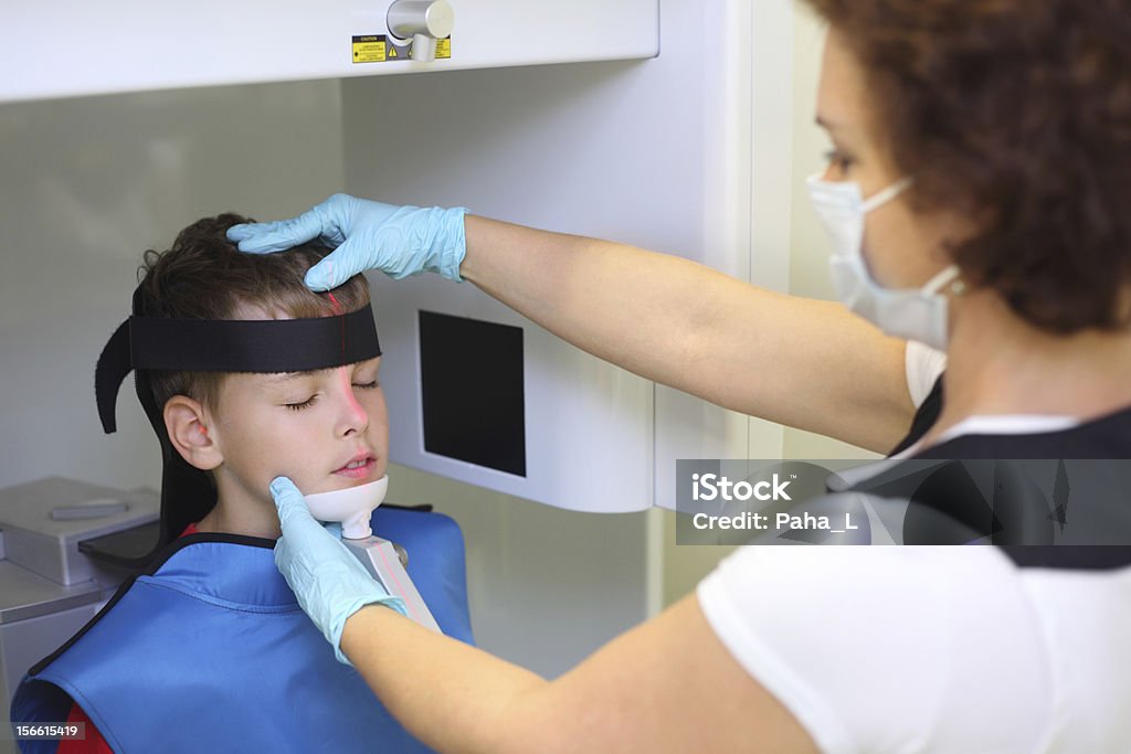 Dentista en máscara prepara boy de mordaza imagen de rayos x - Foto de stock de Asistencia sanitaria y medicina libre de derechos