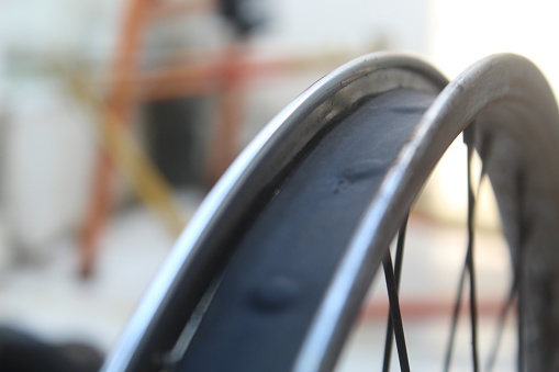 close up of rusty chrome color bicycle wheel with rusty spokes on blur background. suitable for industrial theme and bicycle wheel.