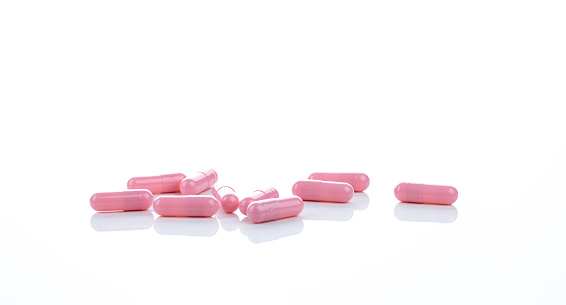 Pink capsule pills on white background. Pharmaceutical industry. Vitamins, minerals, and supplements concept. Pharmacy products. Pharmaceutical medicine. Prescription drugs. Healthcare and medicine.
