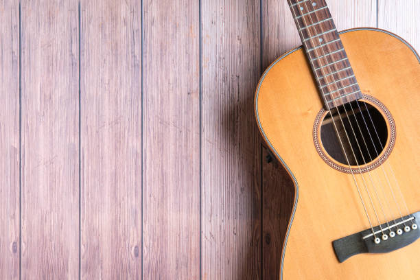 istock Acoustic guitar on rustic wooden background. 1566200514