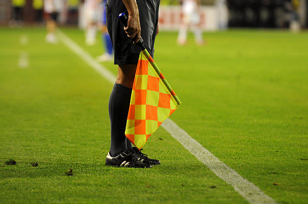 Soccer referee's checkered flag on a soccer field Soccer Referee holding flag referee stock pictures, royalty-free photos & images
