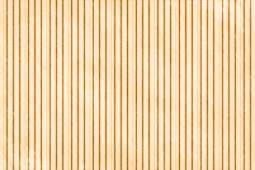 Vector illustration of striped artistic backgrounds resembling textured corrugated paper sheet. There are narrow horizontal parallel stripes all over the light brown background. Apt for use as background, wallpapers, wrapping paper, poster backdrops.