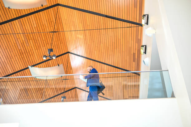 istock Business man in a suit with a briefcase in modern sleek office building 1566248310