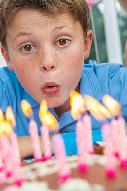 istock Boy Child Blowing Out Birthday Cake Candles 156625391