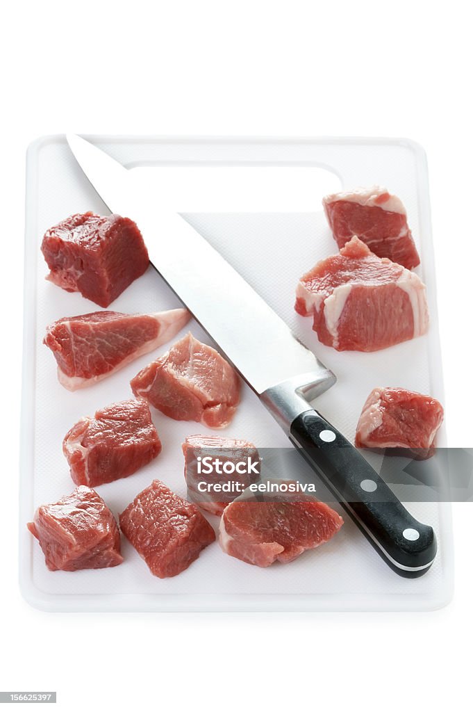 raw cubos de cordeiro em uma tábua de cortar com faca isolado - Foto de stock de Faca de Cozinha royalty-free