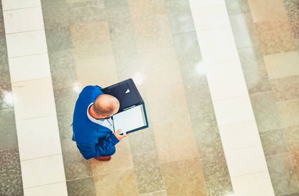 istock Business man in a suit with a folder of work seen from above 1566254028