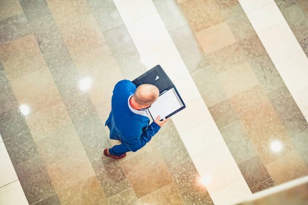 istock Business man in a suit with a folder of work seen from above 1566254697