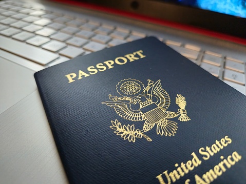 Close Up Of Laptop With USA Passport Sitting Atop