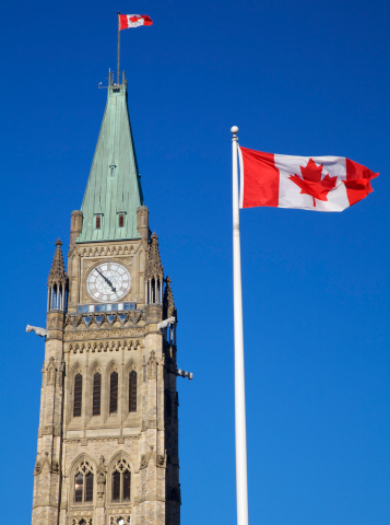 Canadian Flag blowing in a sting breeze on a sunny day with a clear blue sky