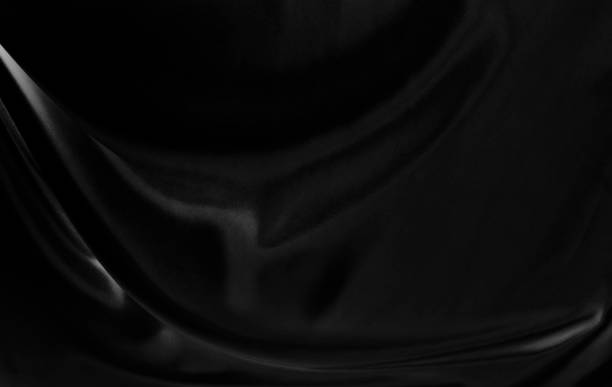 istock Black gray satin dark fabric texture luxurious shiny that is abstract silk cloth background with patterns soft waves blur beautiful. 1566356596