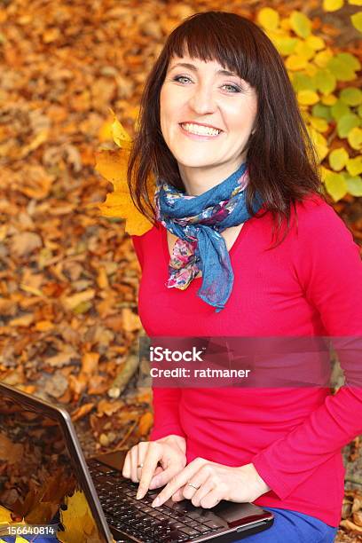 Foto de Mulher Sorridente Com O Laptop No Outono Park e mais fotos de stock de Adulto - Adulto, Amarelo, Beleza